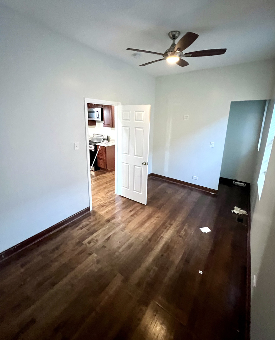 4116 West Cermak Road, Unit 2 Chicago, IL 60623 - Photo 5 of 10 wooden floor in an empty room with a window