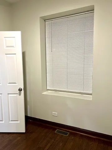 an empty room with wooden floor and a window