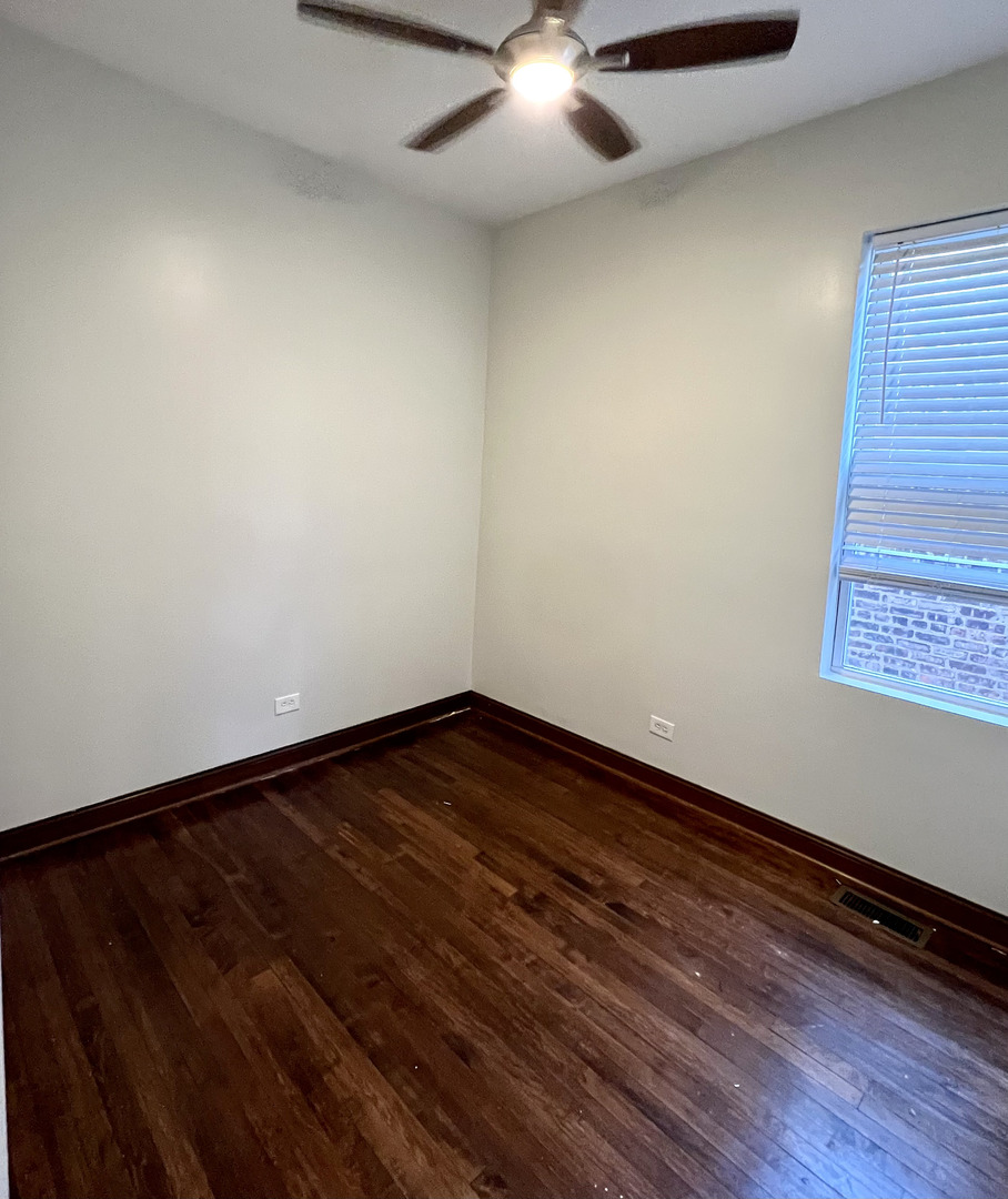 4116 West Cermak Road, Unit 2 Chicago, IL 60623 - Photo 8 of 10 a view of an empty room with wooden floor and a window