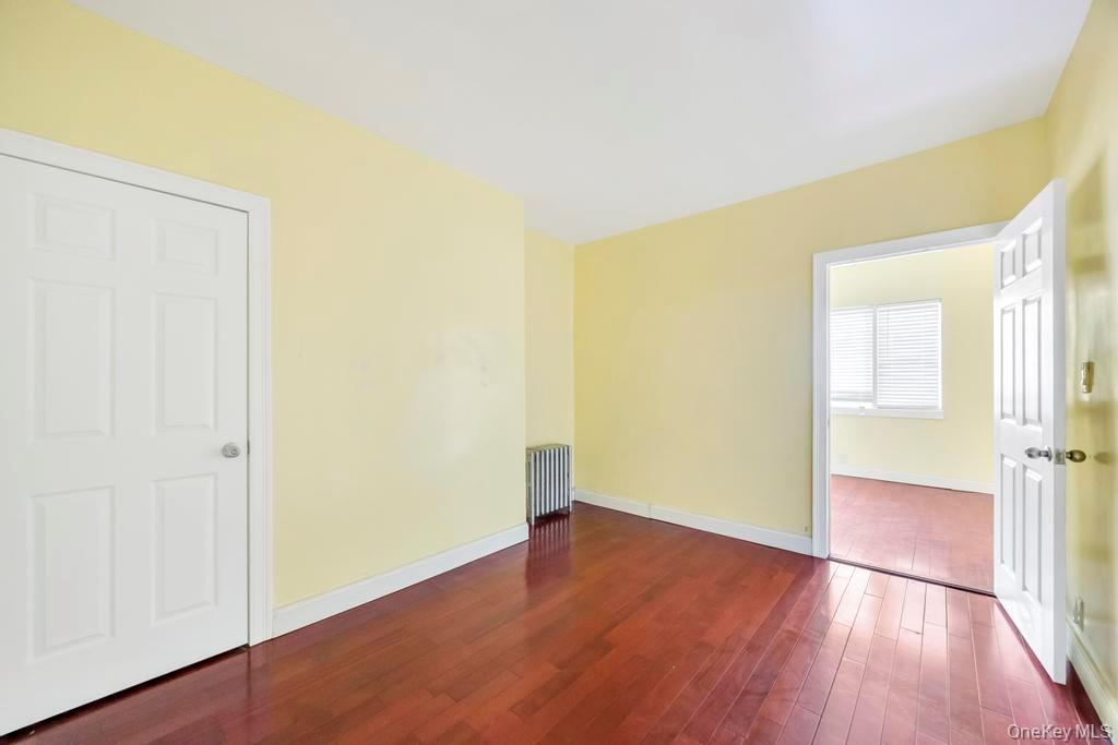 95-26 86th Street Queens, NY 11416 - Photo 19 of 28 Spare room with dark wood finished floors and radiator heating unit