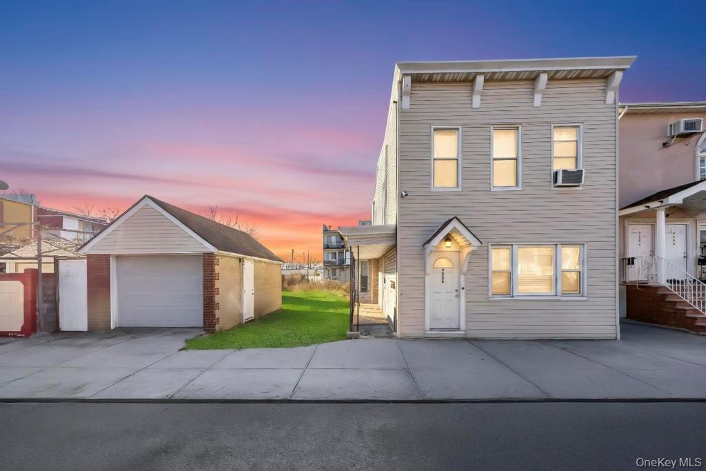 95-26 86th Street Queens, NY 11416 - Photo 2 of 28 View of front of property with an outdoor structure, a detached garage, concrete driveway, and a front yard