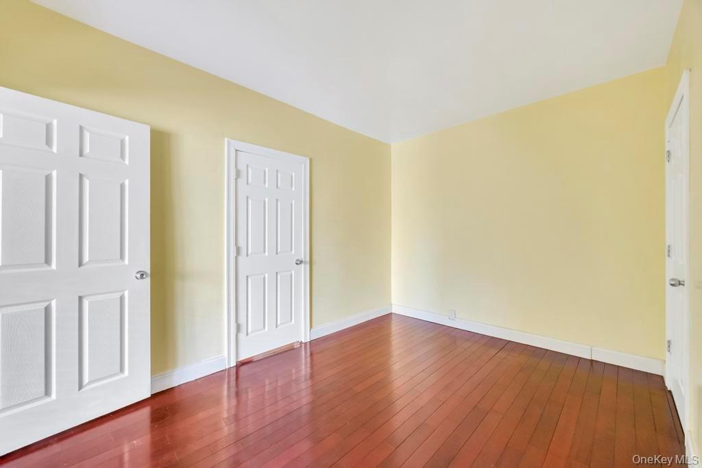 95-26 86th Street Queens, NY 11416 - Photo 24 of 28 Unfurnished bedroom featuring baseboards and dark wood-type flooring