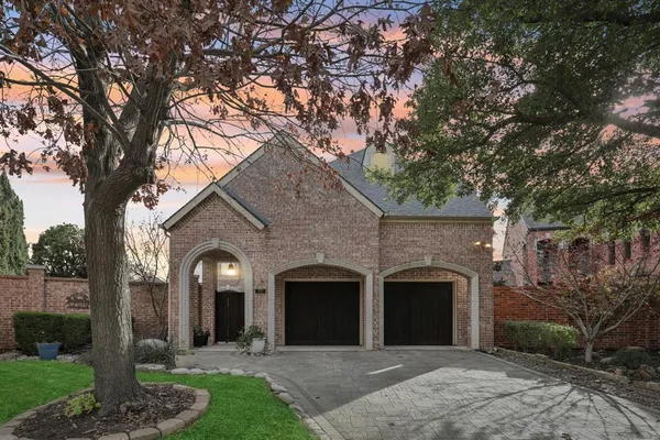 a front view of a house with yard and trees