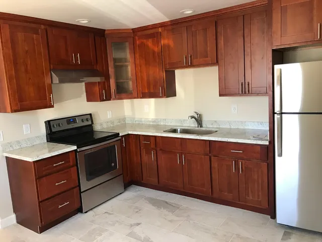 a kitchen with a sink a stove and cabinets