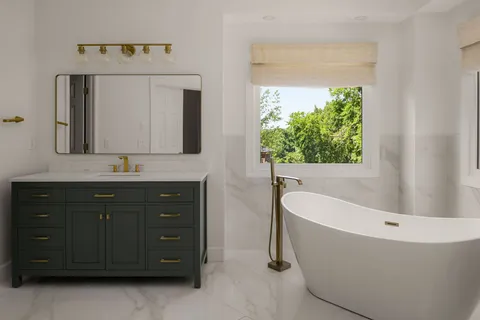 a bathroom with a tub a double vanity sink and mirror