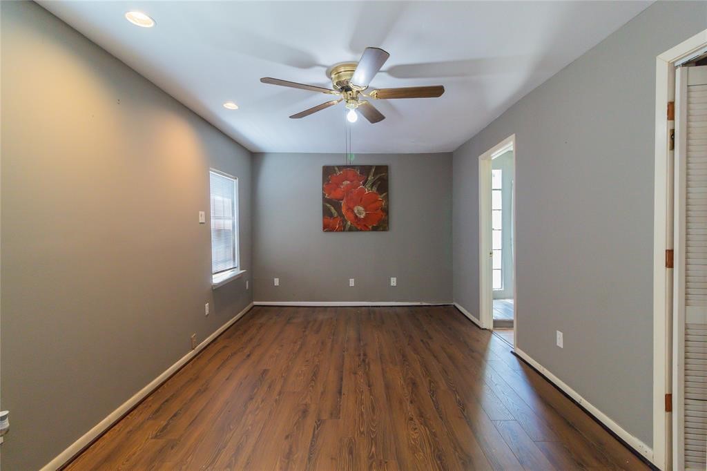 1961 Dryden Road Houston, TX 77030 - Photo 13 of 33 an empty room with wooden floor chandelier fan and windows