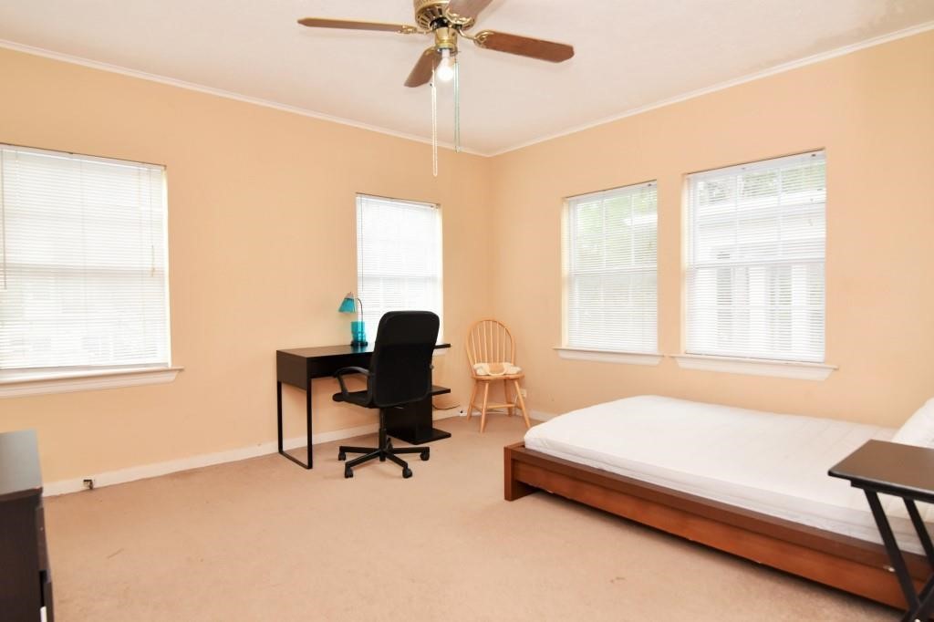 1961 Dryden Road Houston, TX 77030 - Photo 28 of 33 a bedroom with a bed a desk and a chandelier