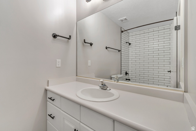 2154 Wasatch Boulevard Sandy, UT 84092 - Photo 9 of 55 Bathroom with vanity, a tile shower, and a textured ceiling