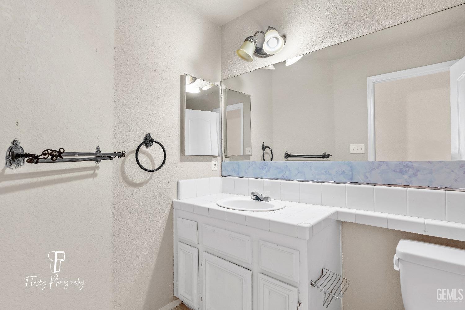 Undisclosed Address Bakersfield, CA 93313 - Photo 15 of 27 a bathroom with a sink and a mirror