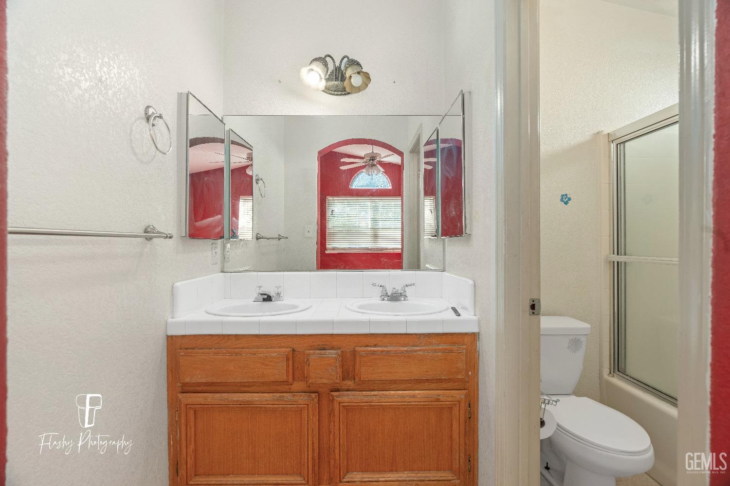Undisclosed Address Bakersfield, CA 93313 - Photo 19 of 27 a bathroom with a sink a mirror a toilet and a shower