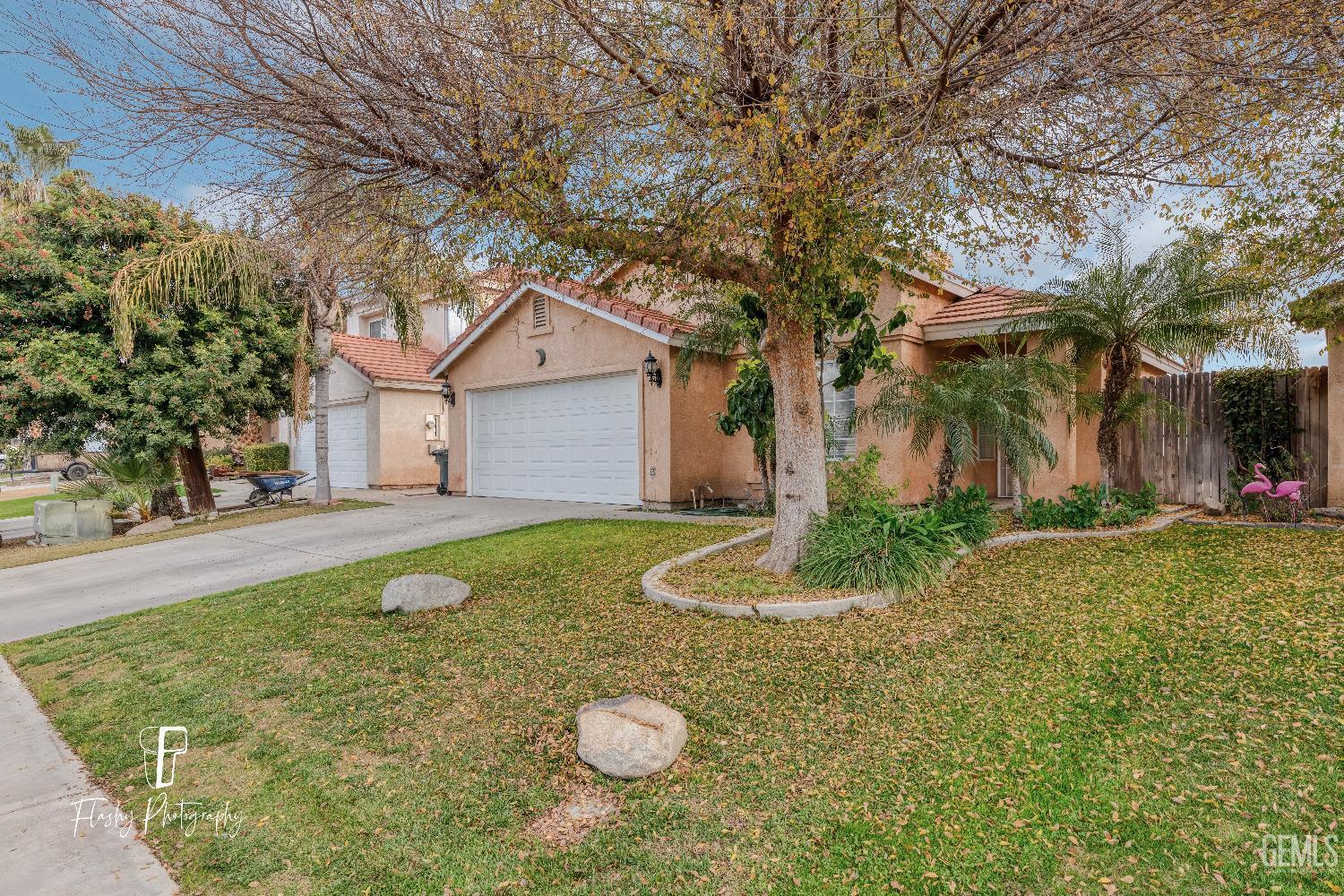 Undisclosed Address Bakersfield, CA 93313 - Photo 3 of 27 a view of a white house with a yard and large tree