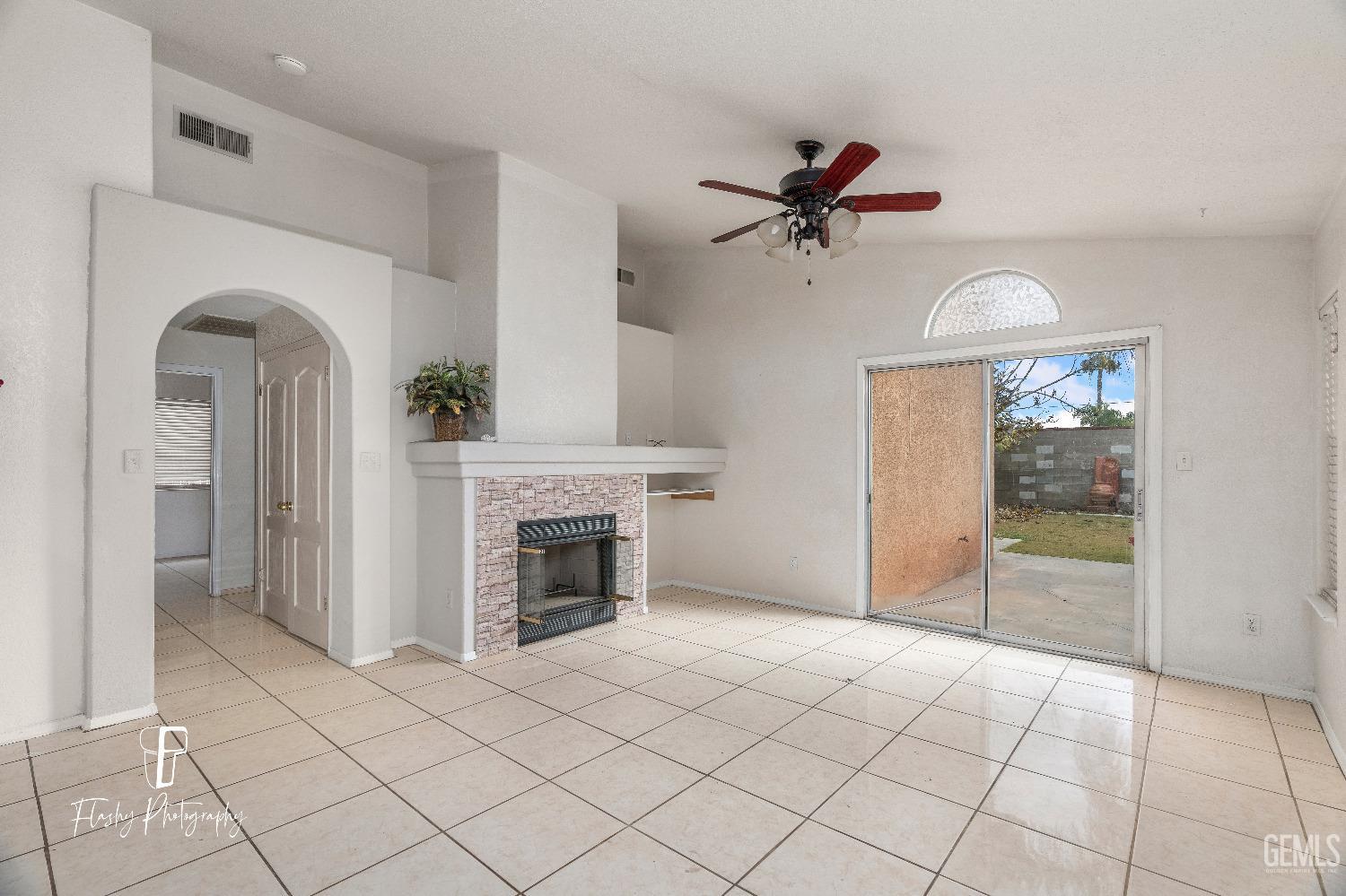 Undisclosed Address Bakersfield, CA 93313 - Photo 10 of 27 a view of a livingroom with a ceiling fan a fireplace and windows