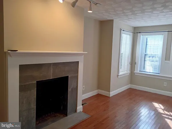a living room with a fireplace and wooden floor