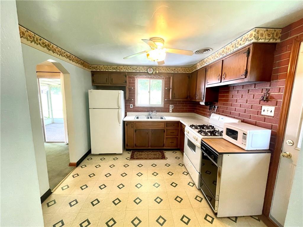 1010 5th Street Baden, PA 15005 - Photo 6 of 21 a kitchen with granite countertop a sink a stove a refrigerator and a window