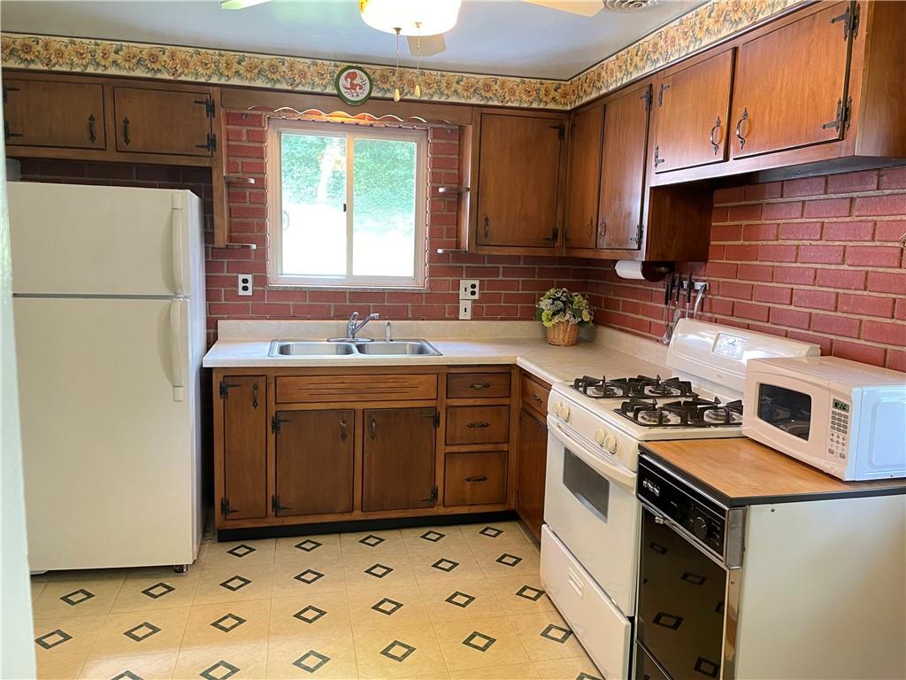 1010 5th Street Baden, PA 15005 - Photo 7 of 21 a kitchen with a stove a sink and a refrigerator
