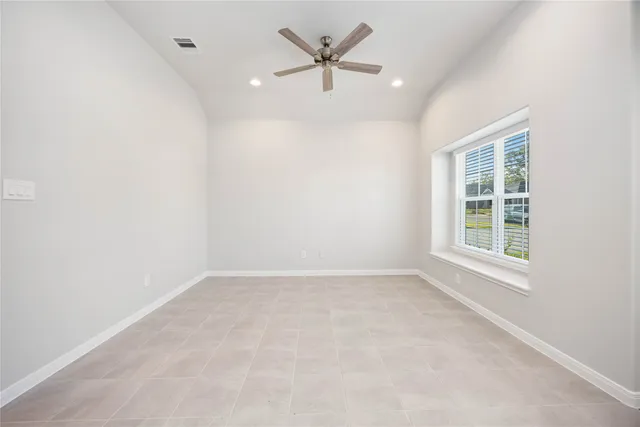 an empty room with a window and a ceiling fan