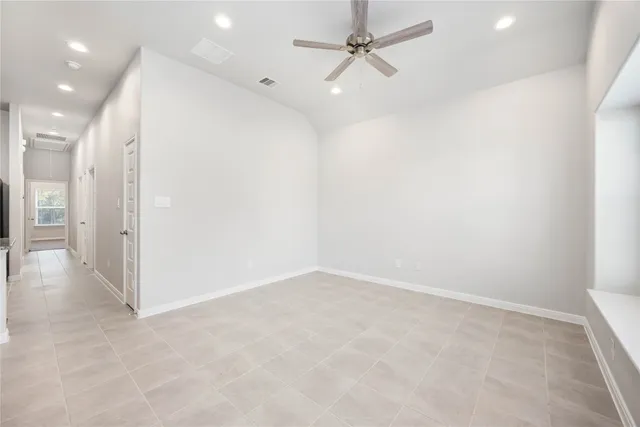 an empty room with fan and entrance