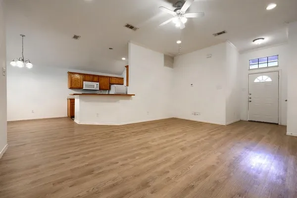 a view of a kitchen with wooden floor and a ceiling fan