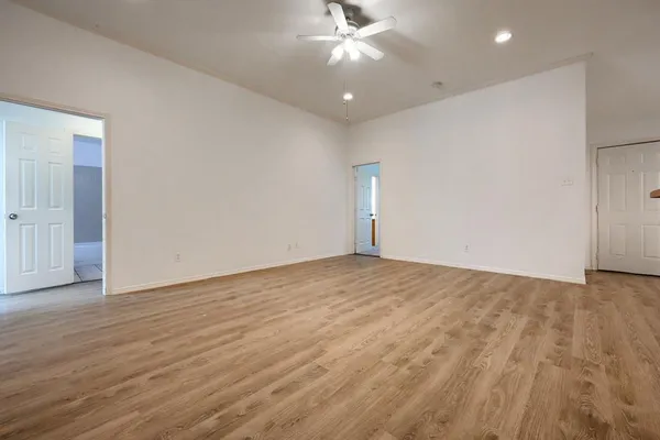 an empty room with wooden floor and windows
