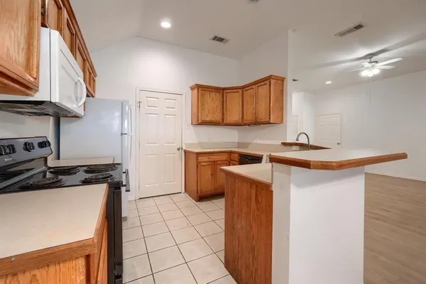 a kitchen with a sink a stove cabinets and a refrigerator