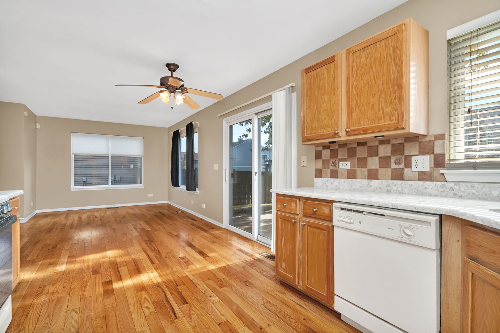 2509 Rosehall Lane Aurora, IL 60503 - Photo 14 of 51 a open kitchen with granite countertop a stove a sink and dishwasher with wooden floor