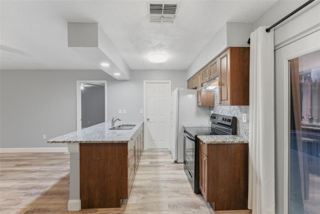 6211 Lorraine Lane Spring Hill, FL 34608 - Photo 11 of 28 a kitchen with stainless steel appliances granite countertop a refrigerator a stove and a sink