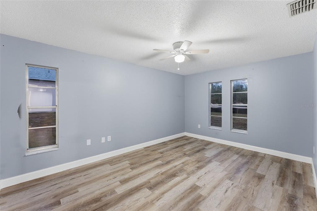 6211 Lorraine Lane Spring Hill, FL 34608 - Photo 14 of 28 a view of an empty room with a window and wooden floor