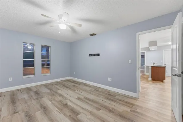 wooden floor in an empty room with a bathroom