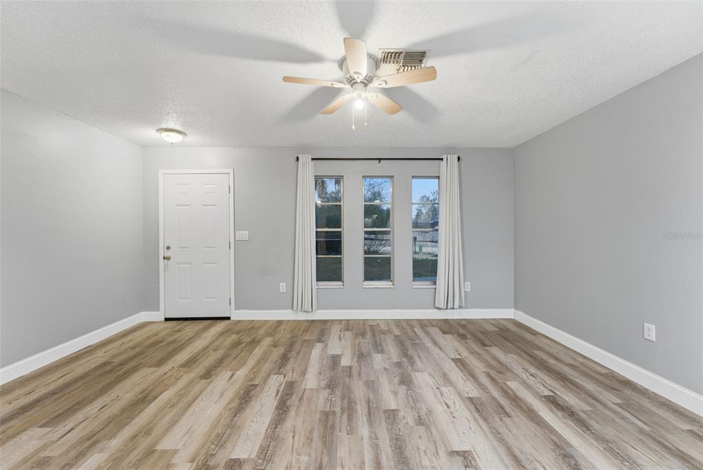6211 Lorraine Lane Spring Hill, FL 34608 - Photo 6 of 28 a view of an empty room with wooden floor and a window