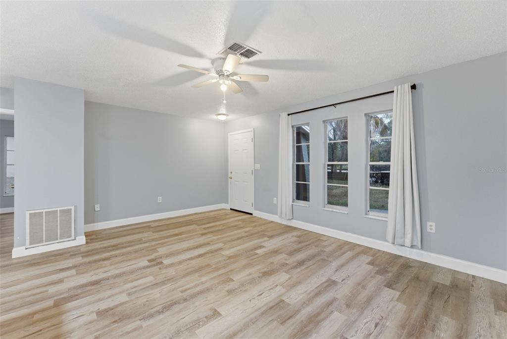 6211 Lorraine Lane Spring Hill, FL 34608 - Photo 7 of 28 a view of an empty room with a window and wooden floor