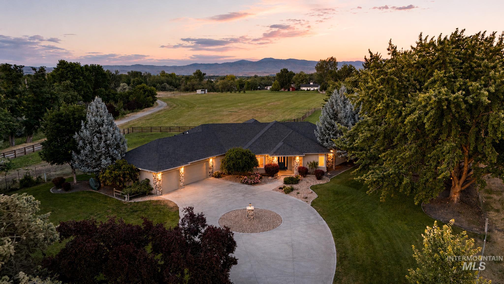 Ranch-style residence featuring a stone facade and dark shingle roof