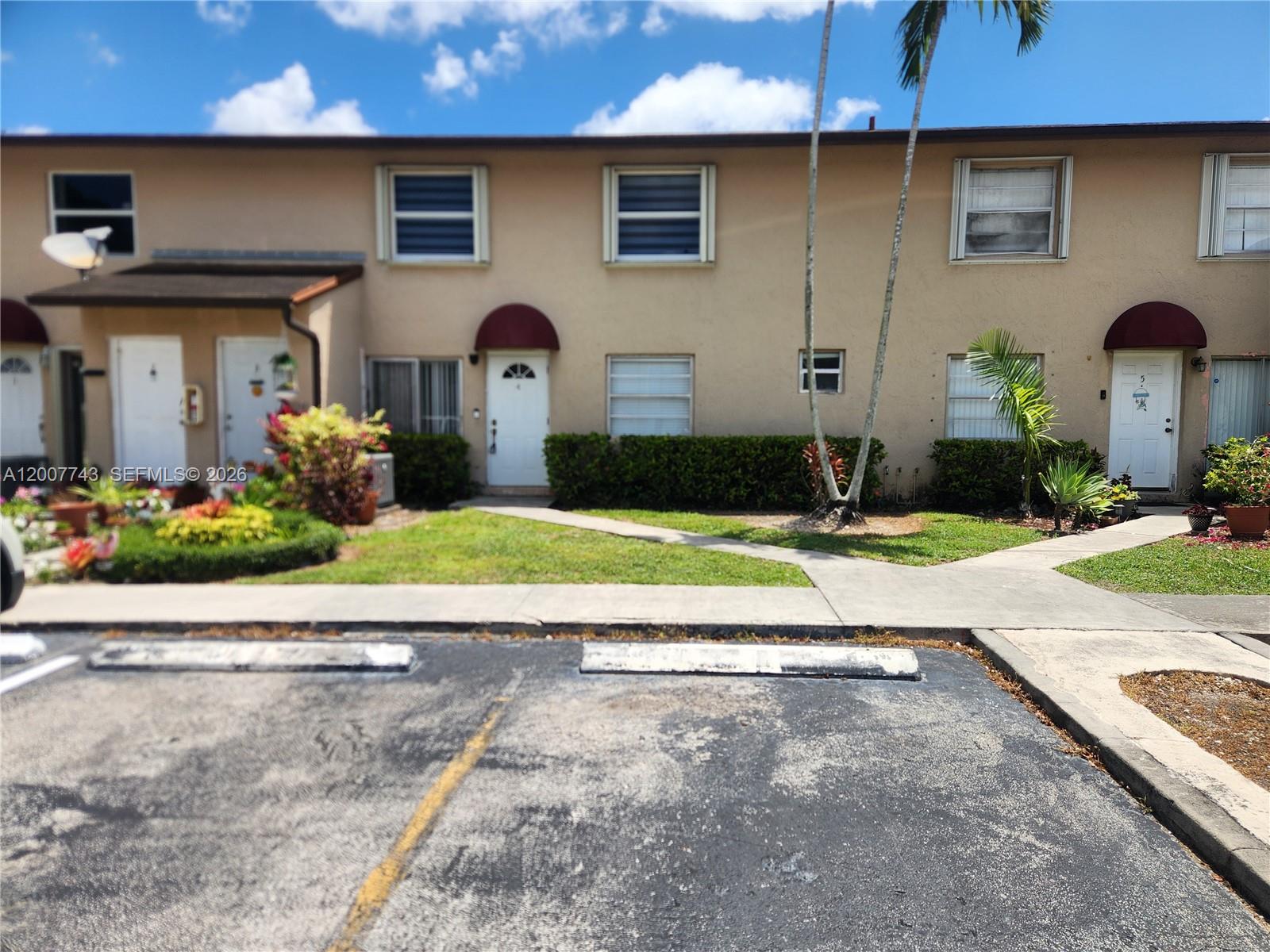 15250 Southwest 80th Street, Unit 4 Miami, FL 33193 - Photo 1 of 18 a front view of a house with garden