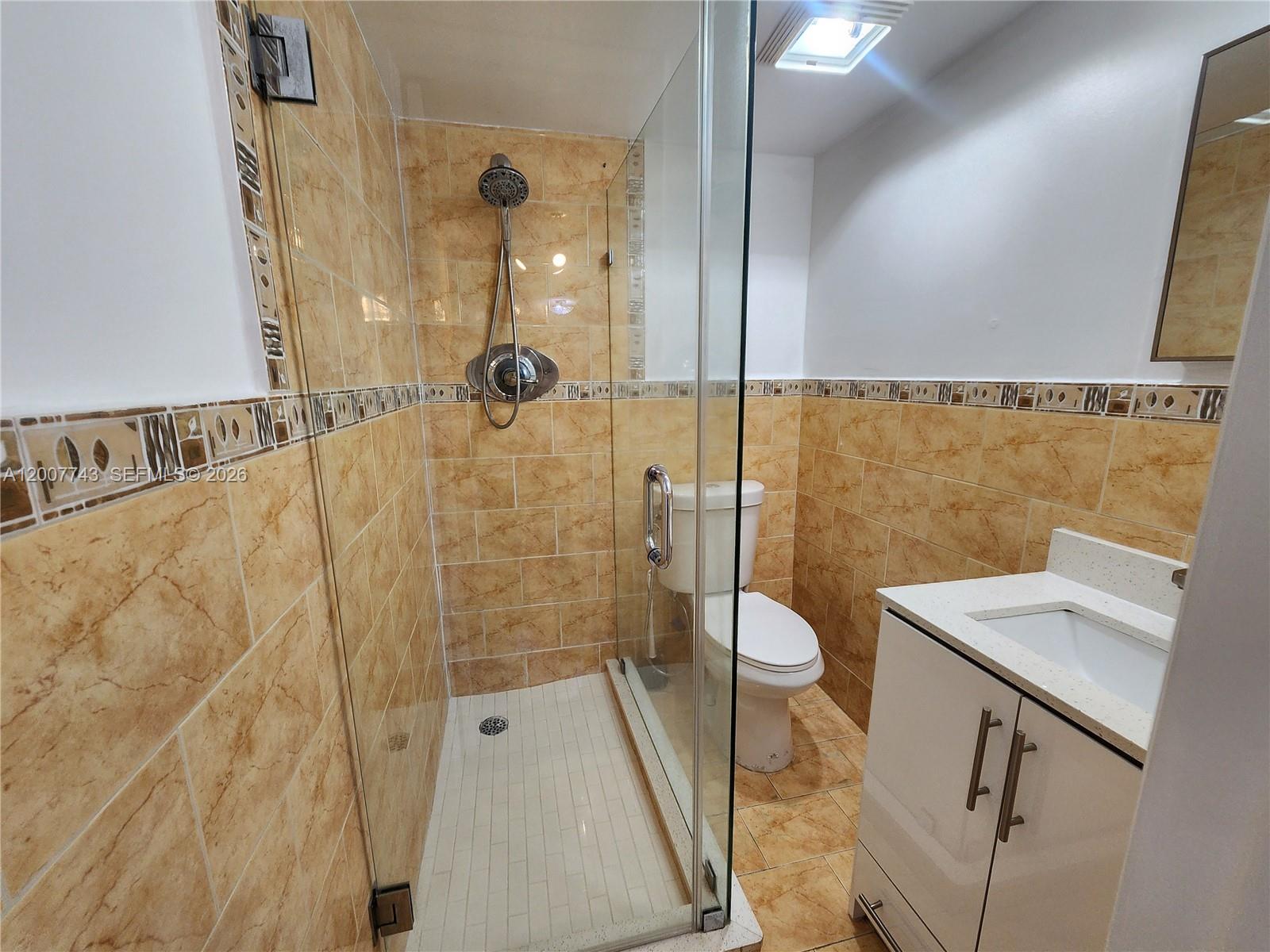 15250 Southwest 80th Street, Unit 4 Miami, FL 33193 - Photo 11 of 18 a bathroom with a granite countertop shower a toilet and a sink