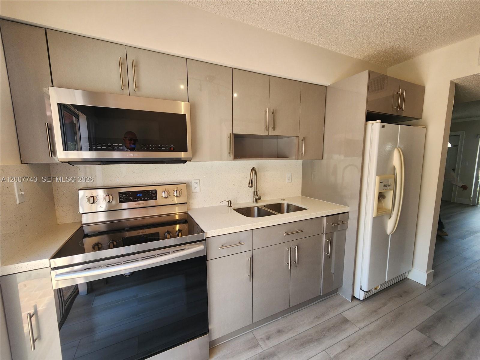 15250 Southwest 80th Street, Unit 4 Miami, FL 33193 - Photo 2 of 18 a kitchen with stainless steel appliances a stove a microwave and a hard wood floors