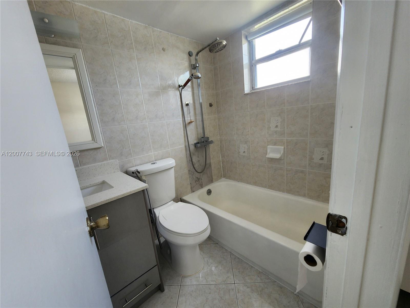 15250 Southwest 80th Street, Unit 4 Miami, FL 33193 - Photo 9 of 18 a bathroom with a granite countertop toilet a sink and a bathtub