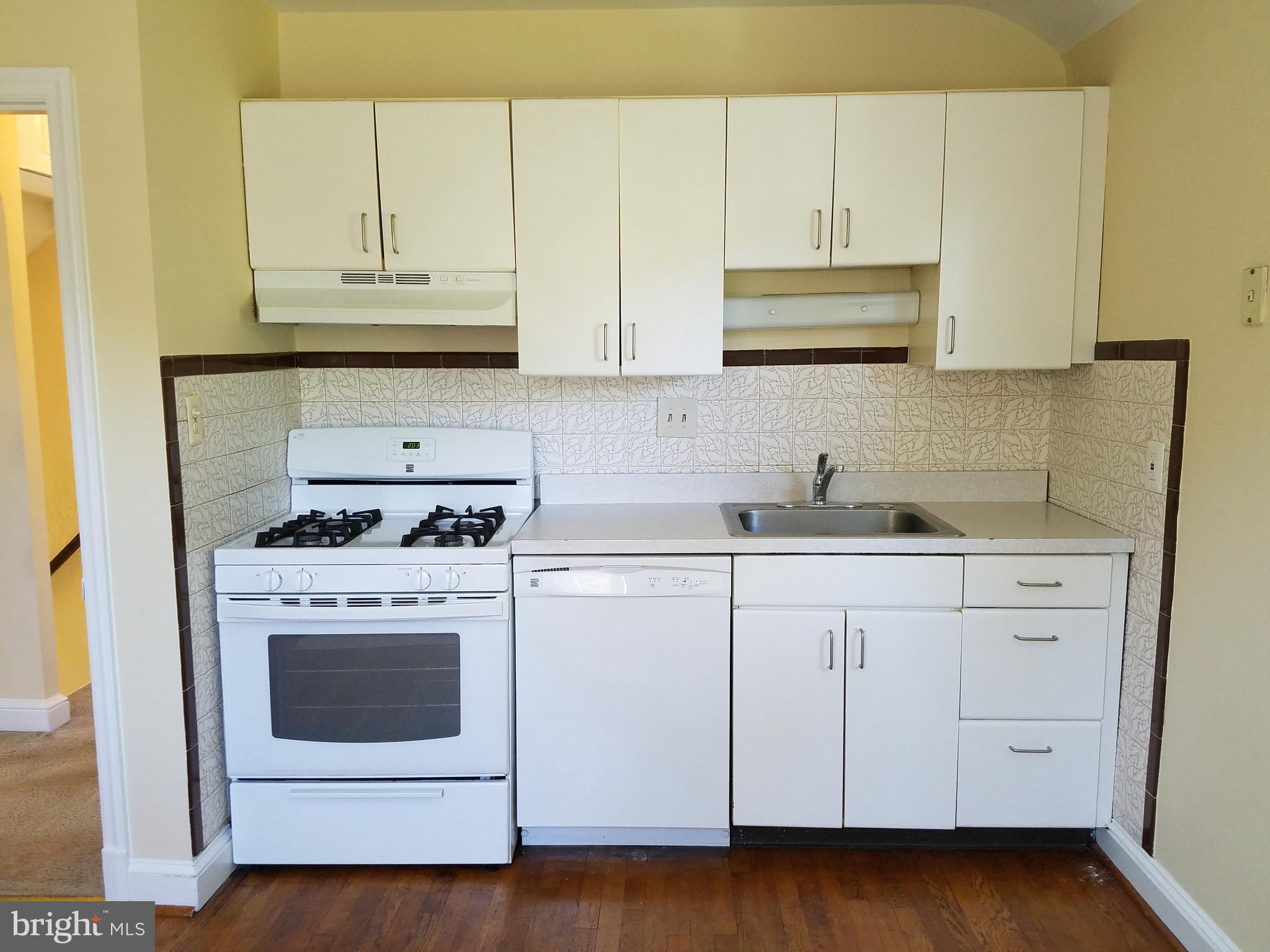 5561 Ashbourne Road Halethorpe, MD 21227 - Photo 13 of 21 a kitchen with white cabinets and white appliances