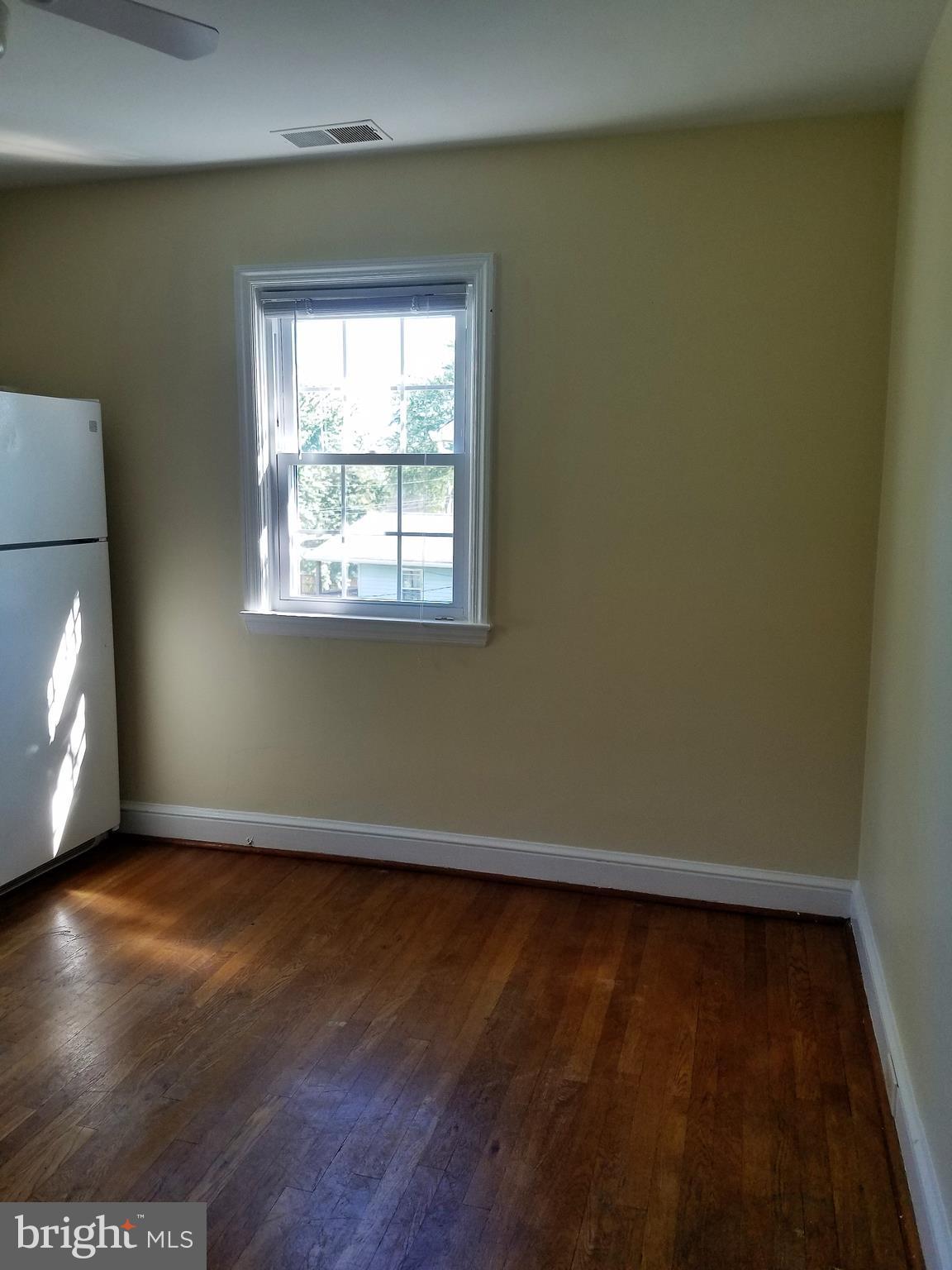 5561 Ashbourne Road Halethorpe, MD 21227 - Photo 15 of 21 an empty room with wooden floor and windows