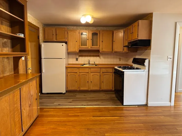 a kitchen with a sink a refrigerator and cabinets
