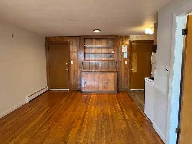 a view of empty room with wooden floor