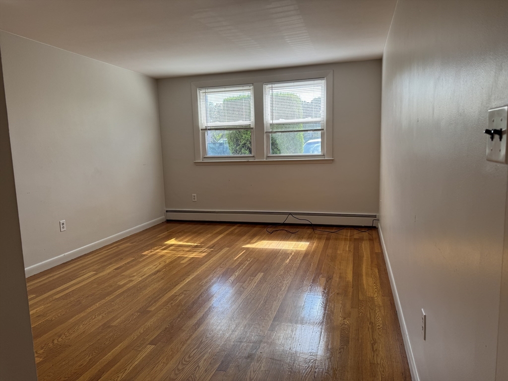 100 Magnolia Avenue, Unit 5 Lynn, MA 01904 - Photo 9 of 16 an empty room with wooden floor and windows