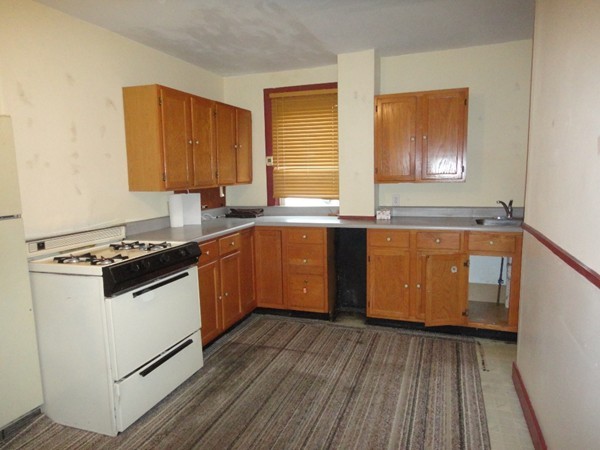 89 Spring Street Fairhaven, MA 02719 - Photo 25 of 27 a kitchen with stainless steel appliances granite countertop wooden cabinets a sink a stove a refrigerator and island