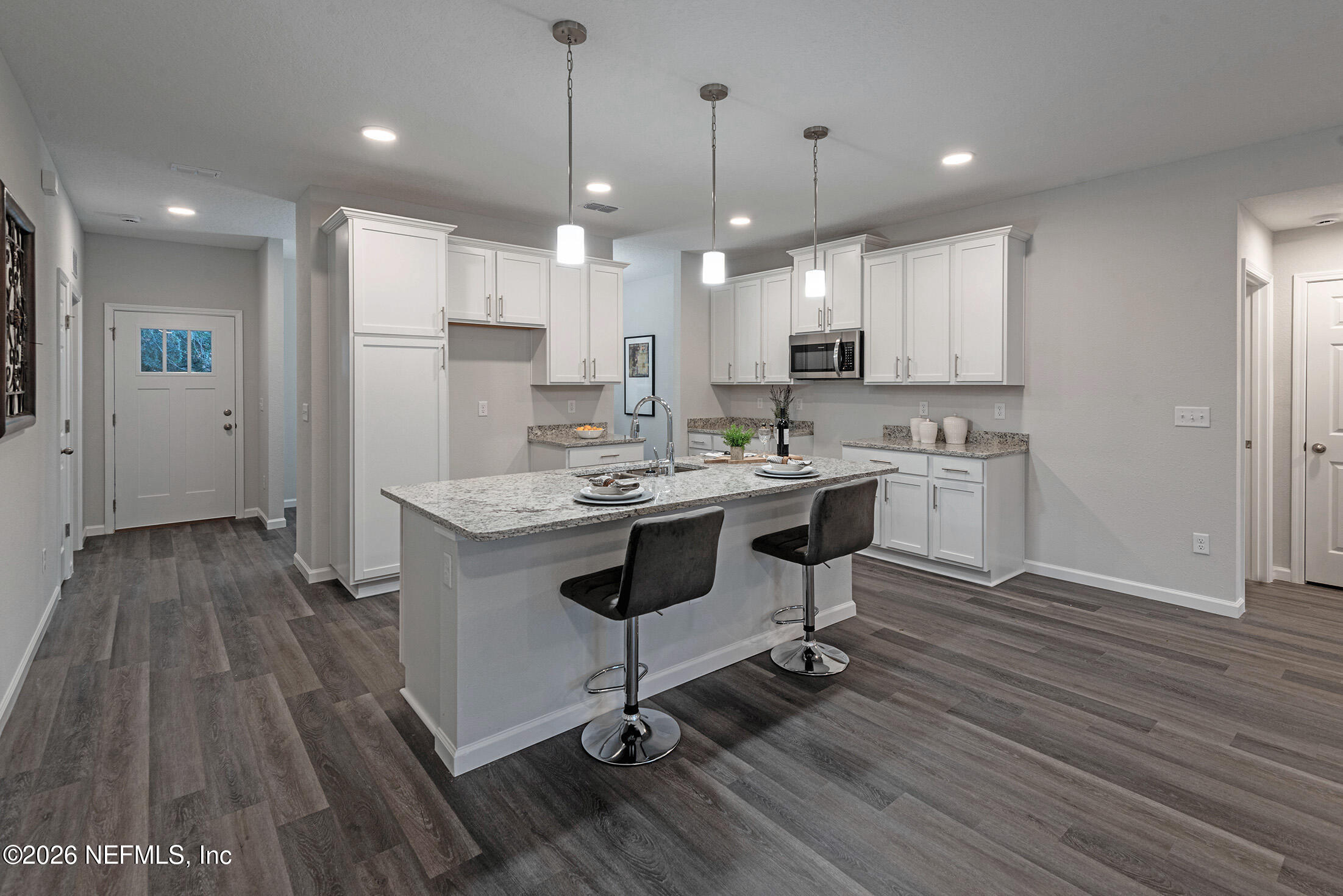 13748 Coman Road Jacksonville, FL 32218 - Photo 14 of 34 a kitchen with kitchen island stainless steel appliances a stove a sink a refrigerator white cabinets and wooden floor