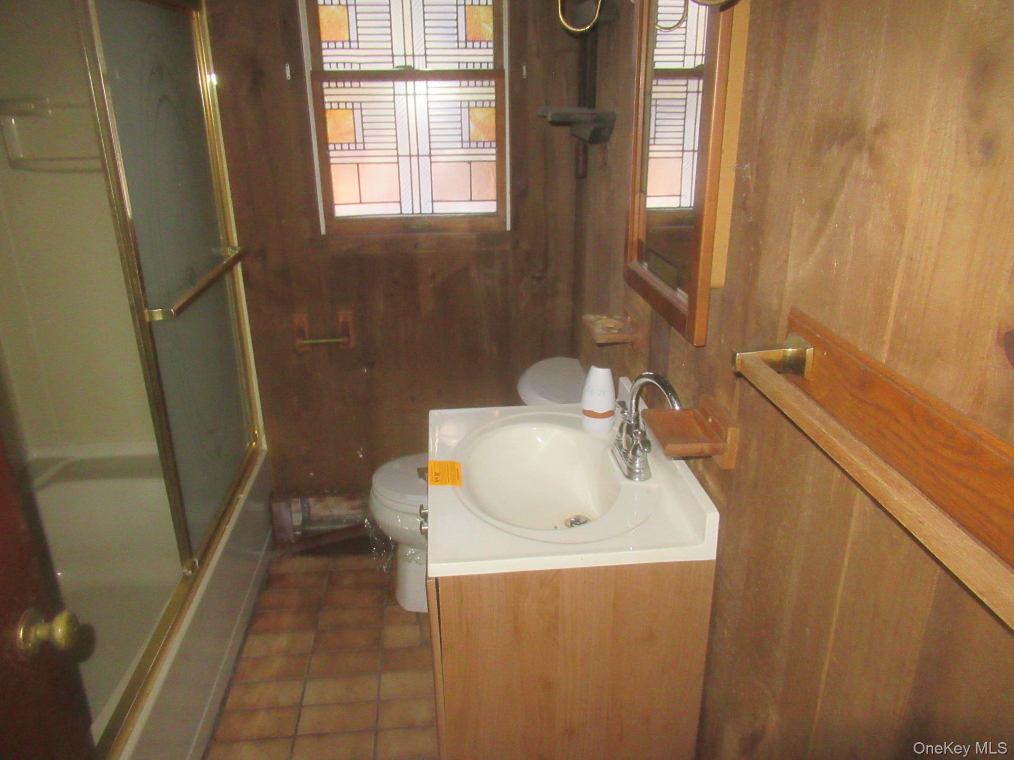 270 Bucks Hollow Road Mahopac, NY 10541 - Photo 11 of 11 Bathroom with wood walls, vanity, tile patterned floors, and combined bath / shower with glass door