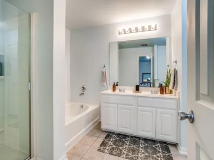 a spacious bedroom with a bed and a chandelier