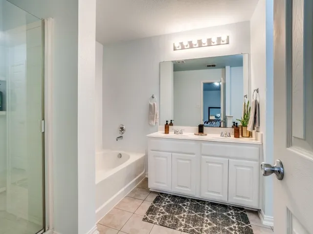 a spacious bedroom with a bed and a chandelier