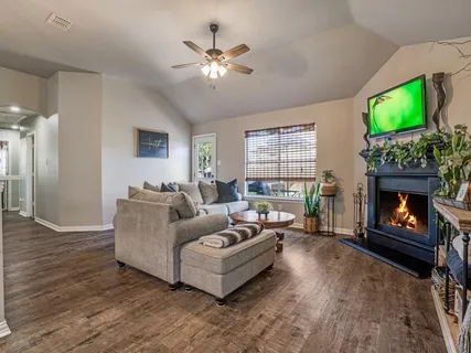 a living room with furniture a fireplace and a flat screen tv