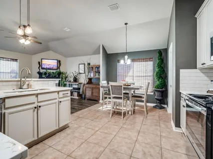 a kitchen with stainless steel appliances granite countertop table chairs sink and cabinets
