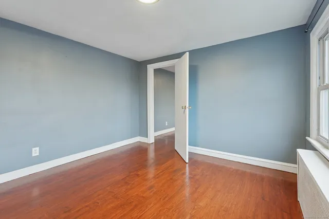 a view of an empty room with wooden floor