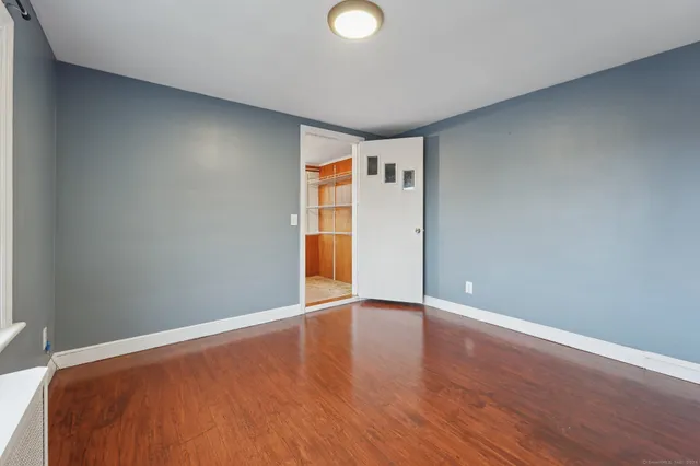 a view of an empty room with wooden floor