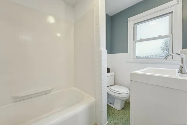 a bath room with a toilet a sink and a bath tub